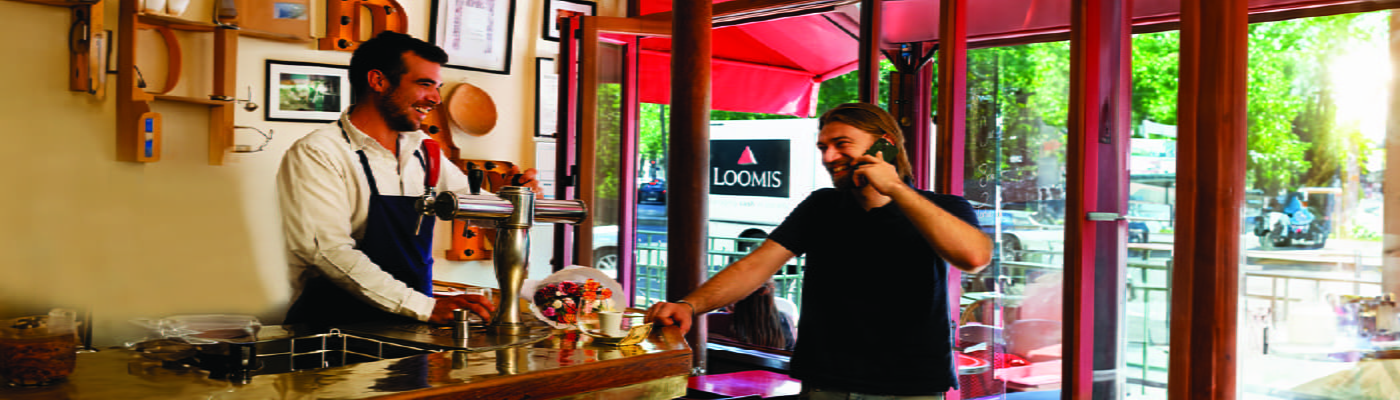 man-on-phone-with-barista-with-cash-on-counter-100