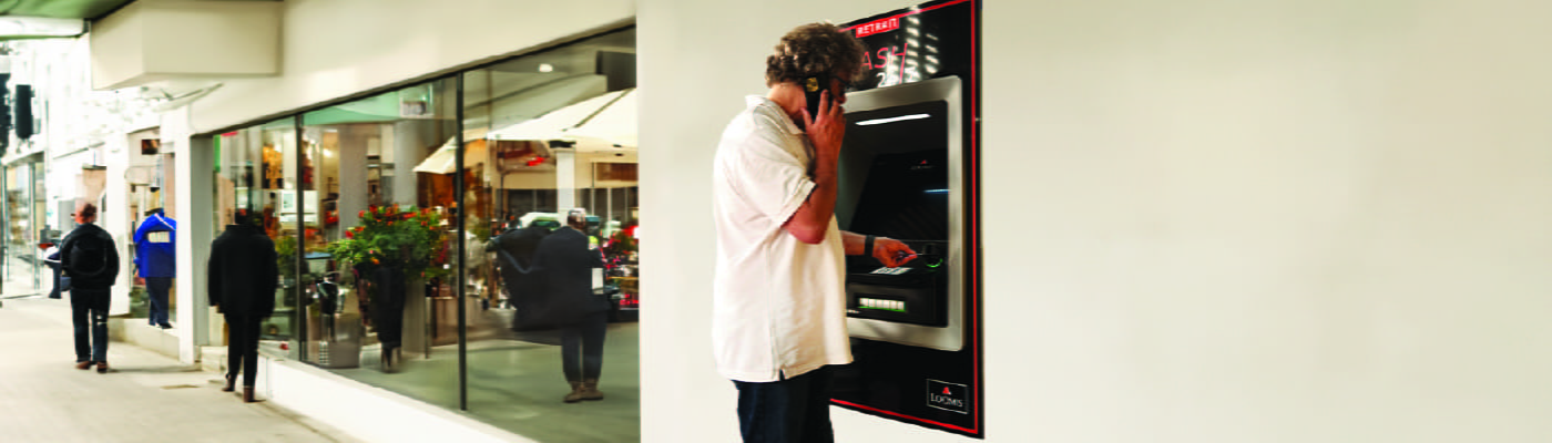 man-on-phone-withdrawing-cash-from-loomis-cash-24-7-ATM-100